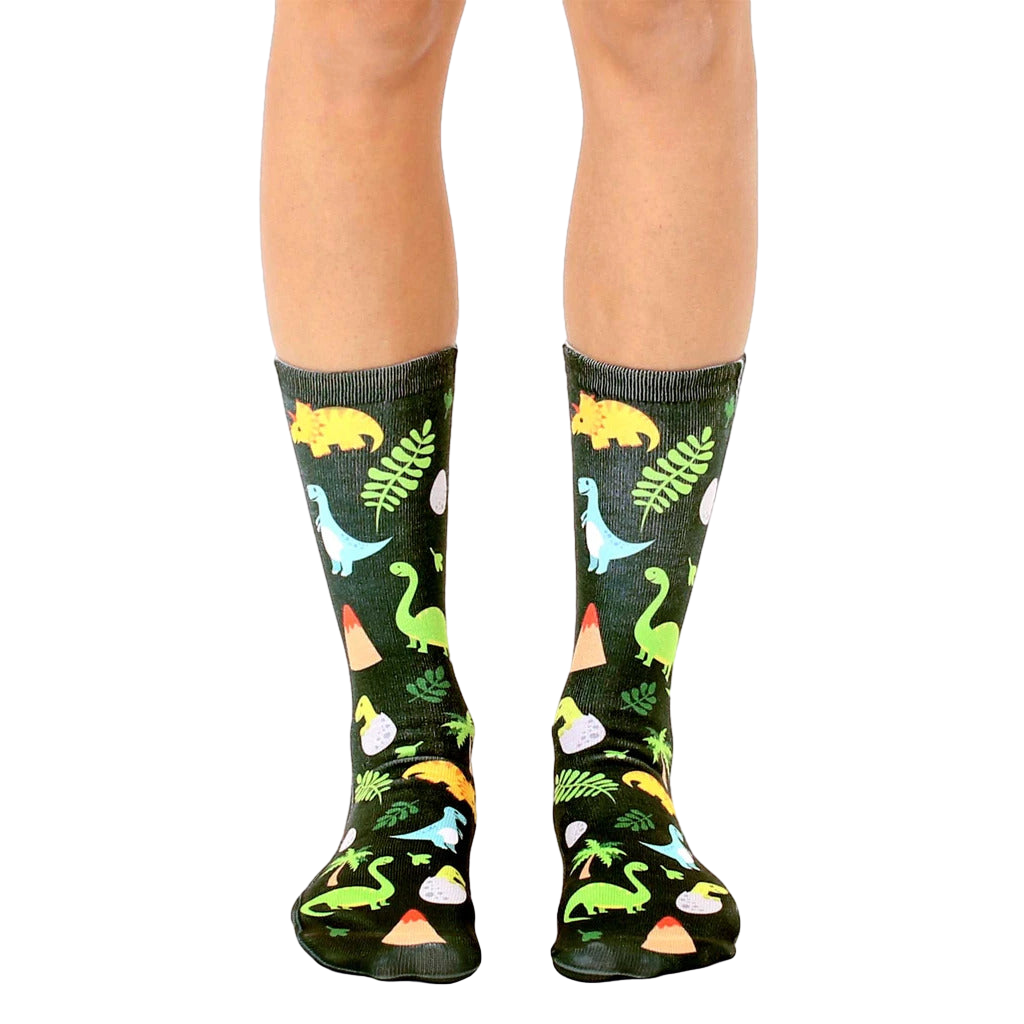 Crew socks in dark green with colorful dinosaurs, volcano, and foliage illustrations. [lf]