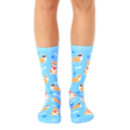 A pair of light blue crew socks featuring a repeating pattern of cute corgis wearing sunglasses, bandanas, and bows, alongside bones and paw prints. [lf]