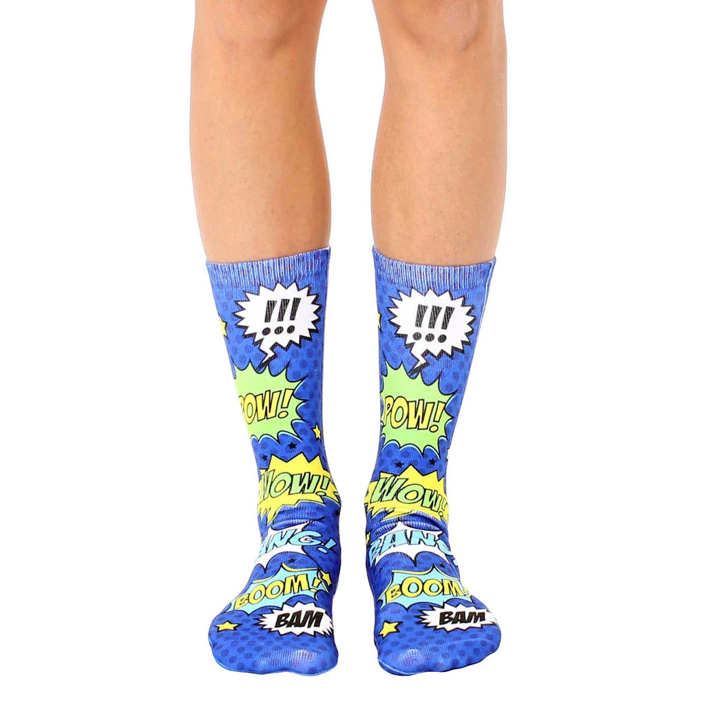 A pair of blue crew socks with a comic book design featuring yellow and green speech bubbles that say 'Pow!', 'Bam!', and 'Wow!' [lf]
