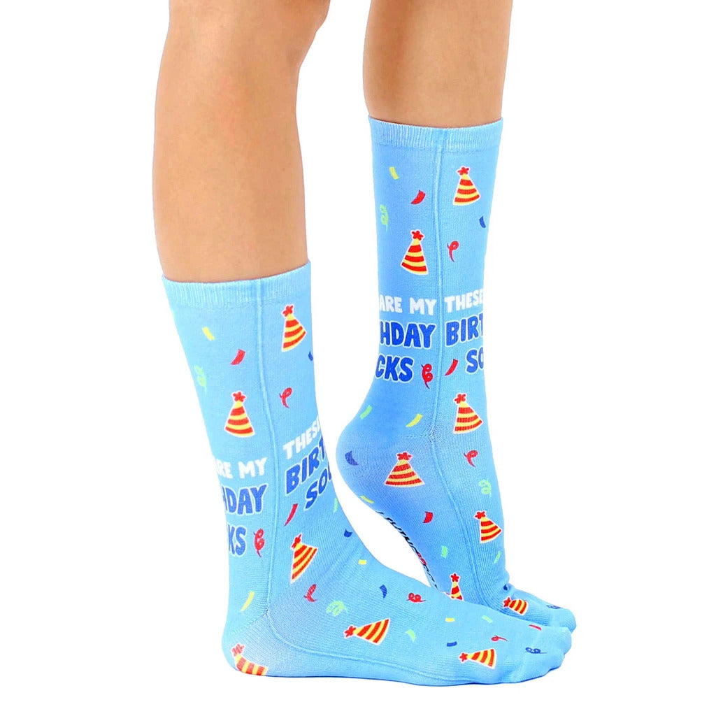 Lifestyle shot of a person's legs wearing the birthday socks. The socks are prominently displayed in a casual setting. [lf]