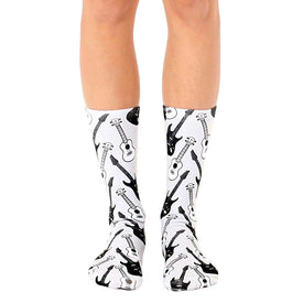 **alt text:**  white crew socks with a black pattern of guitars and ukeleles for men and women.   