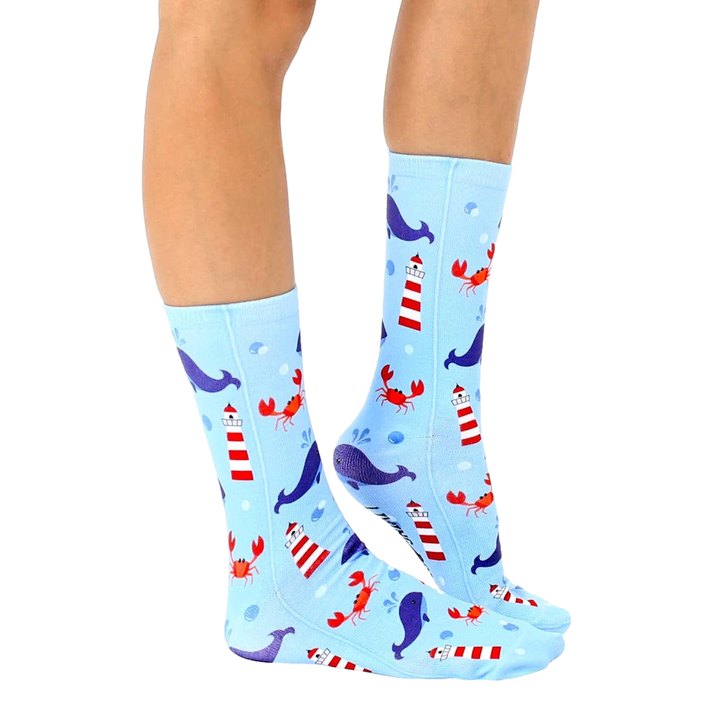 Lifestyle shot of a person's legs wearing the Lighthouse Whale socks, showcasing the design and fit. [lf]