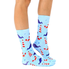 Lifestyle shot of a person's legs wearing the Lighthouse Whale socks, showcasing the design and fit. [lf]
