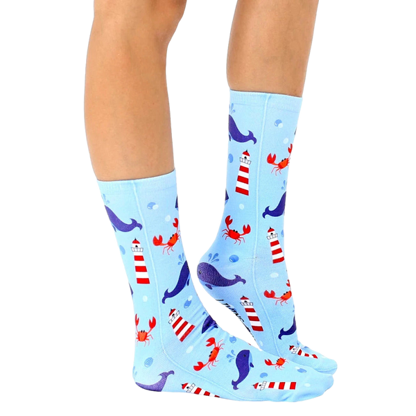 Lifestyle shot of a person's legs wearing the Lighthouse Whale socks, showcasing the design and fit. [lf]