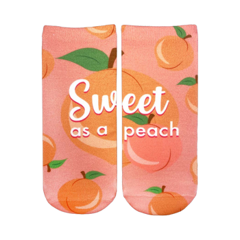 Pair of pink ankle socks with a peach pattern.  The socks say 'Sweet as a peach' in white script. Peaches are illustrated with green leaves.