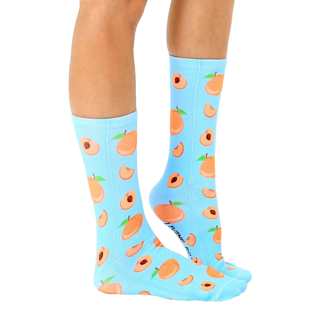 Lifestyle shot: Person wearing light blue peach socks with the socks slightly angled. [lf]