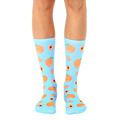 Pair of light blue crew socks with an all-over print of peaches and peach slices. [lf]