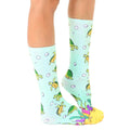 Side view of teal crew socks with sea turtle pattern, showing the sock's fit and design details. [lf]