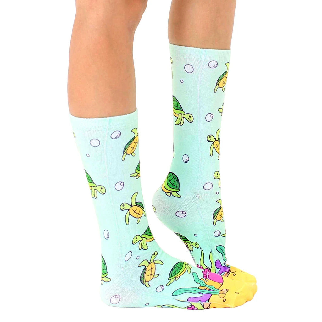 Side view of teal crew socks with sea turtle pattern, showing the sock's fit and design details. [lf]