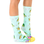 Side view of teal crew socks with sea turtle pattern, showing the sock's fit and design details. [lf]