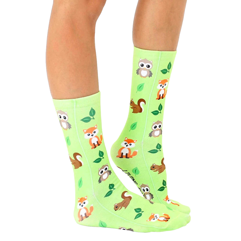 Lifestyle shot of lime green Woodland Animal socks on a person's legs, showcasing the socks in a natural setting. [lf]
