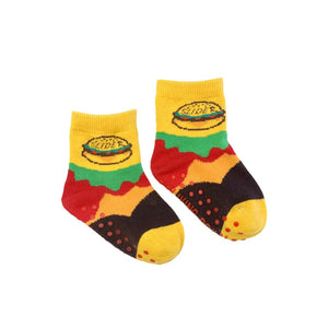 A pair of yellow baby socks with a hamburger graphic on the front and non-skid soles.