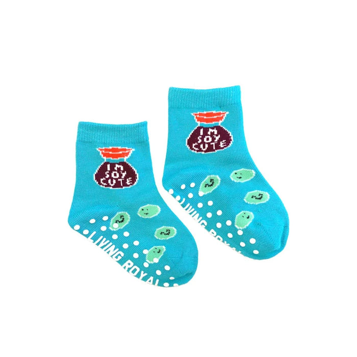 A pair of blue baby socks with a soy sauce packet graphic that says 