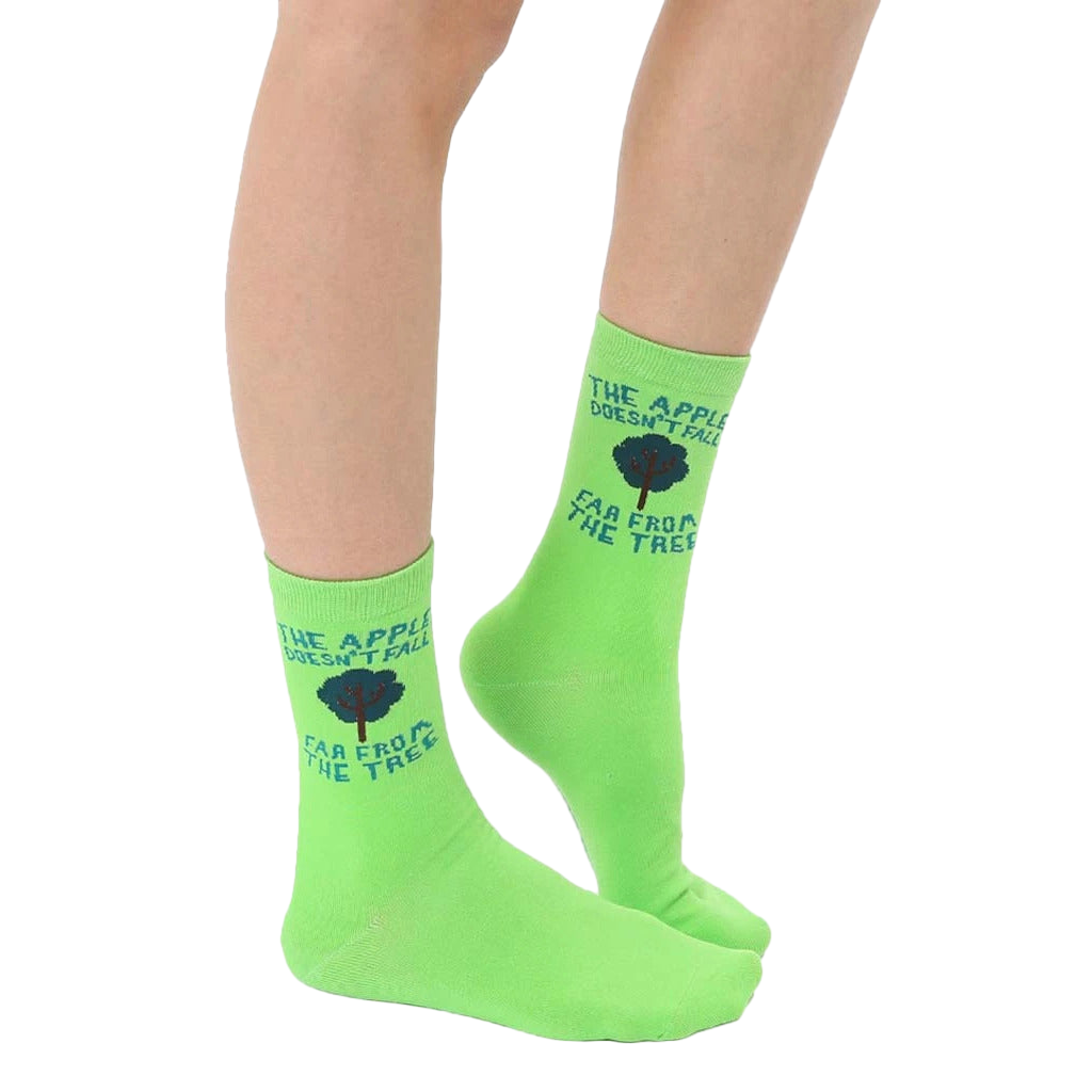 A pair of women's lime green crew socks with the phrase 'The apple doesn't fall far from the tree' and a small tree graphic. [lf]