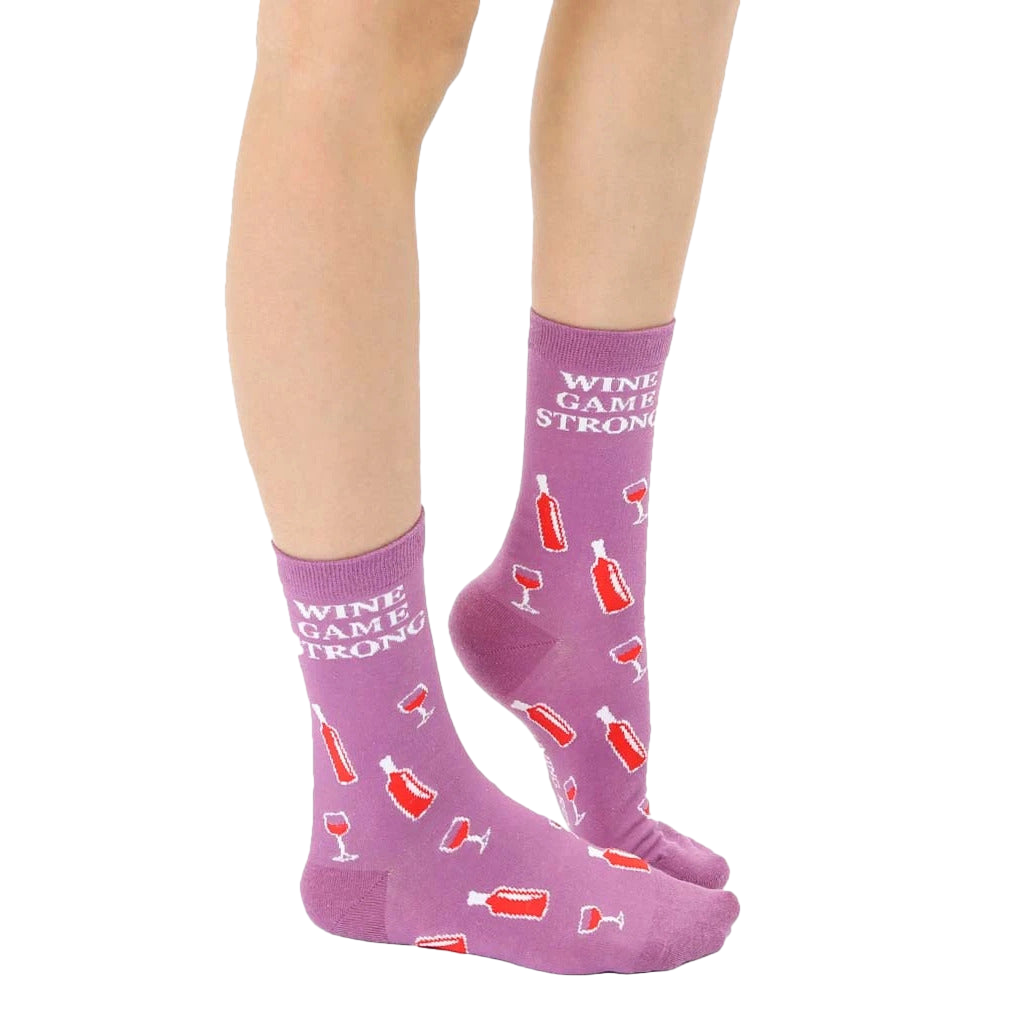 Close-up of adult 'Wine Game Strong' socks on a model's feet, showcasing the sock's design and color. [lf]