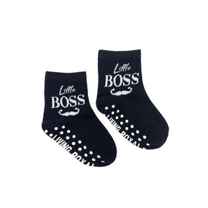 A pair of black baby socks with white soles and the words 