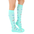 Side view of a person wearing a pair of mint green knee-high Dentist socks. [lf]