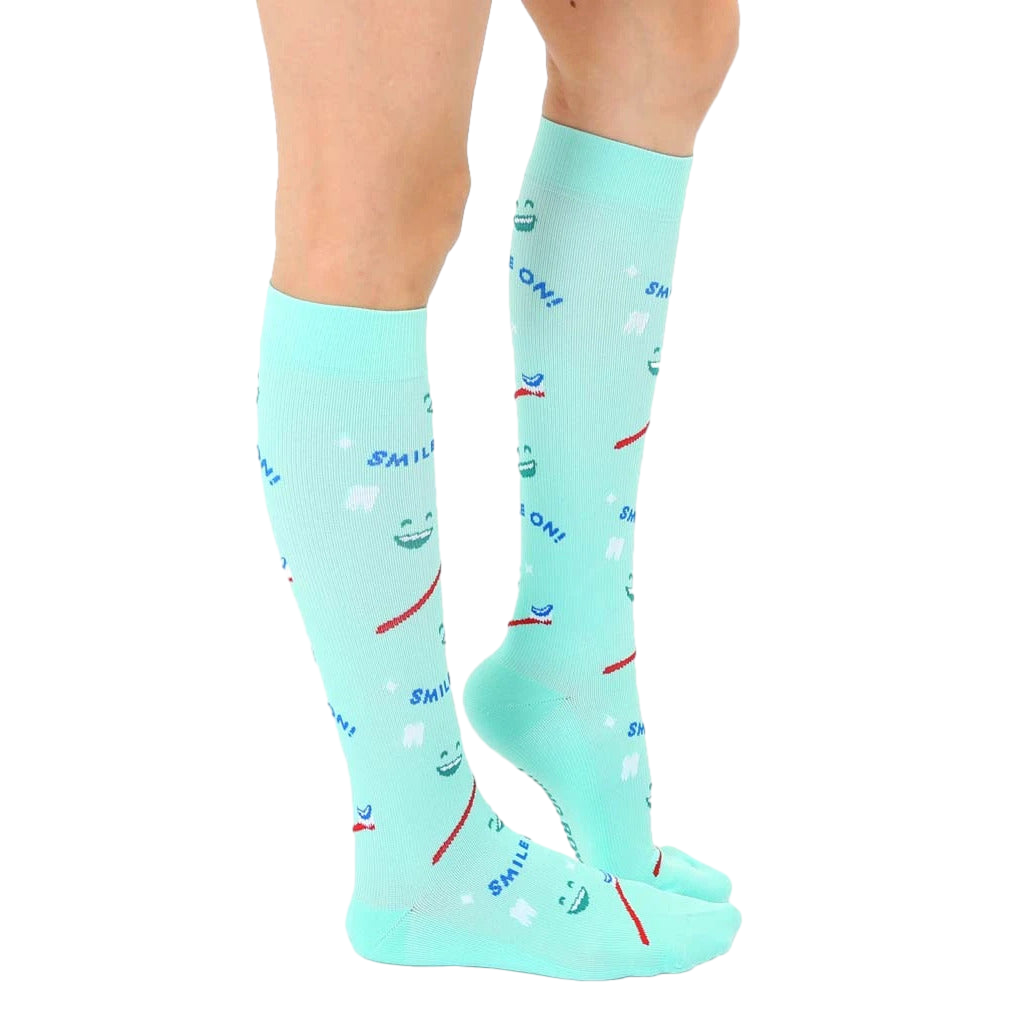 Side view of a person wearing a pair of mint green knee-high Dentist socks. [lf]