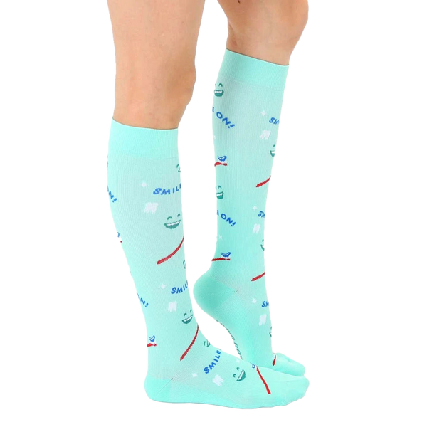 Side view of a person wearing a pair of mint green knee-high Dentist socks. [lf]