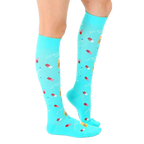 Lifestyle shot of a person wearing the turquoise "Best Medicine" knee-high socks. [lf]