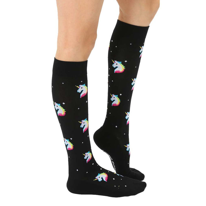 A pair of black knee-high socks with a pattern of pixelated unicorn heads in rainbow colors.