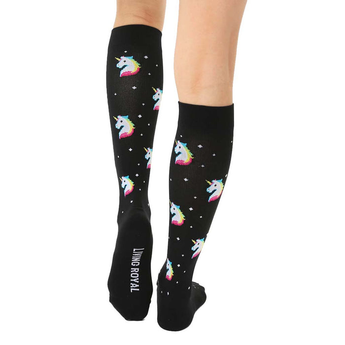 A pair of black knee-high socks with a pattern of pixelated unicorn heads in rainbow colors.