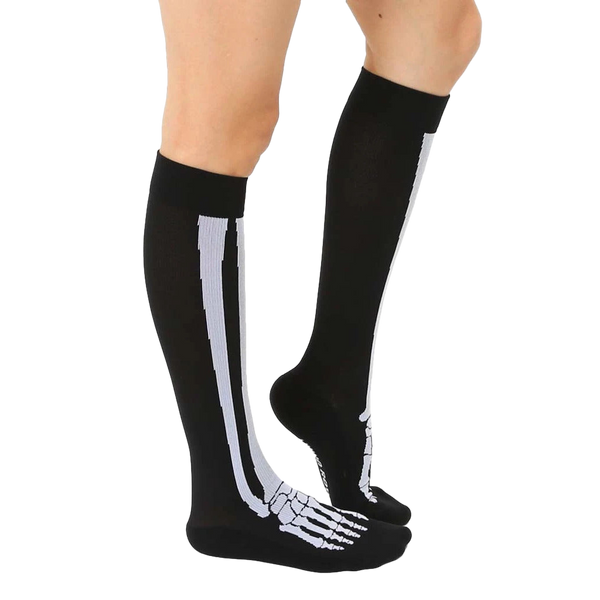 Lifestyle shot of a person wearing black knee-high skeleton socks. The socks are slightly angled, showing off the design. [lf]