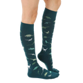 Lifestyle shot showing the teal dinosaur socks on a person's legs. [lf]