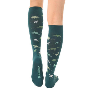 A pair of dark green knee-high socks with a pattern of small dinosaurs in lighter green.