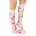 Lifestyle shot showing the floral knee-high socks on a model's legs, showcasing how they look when worn. [lf]