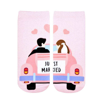 pink ankle socks featuring a newlywed couple driving off in a pink car with "just married" on the back window and hearts above.  