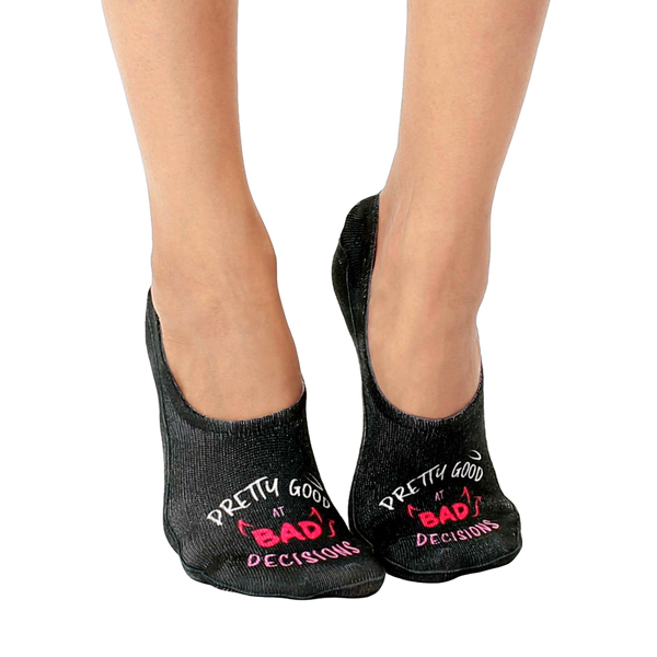 Pair of black no-show socks with a pink 'Pretty good at bad decisions' slogan and small devil horns graphic. [lf]