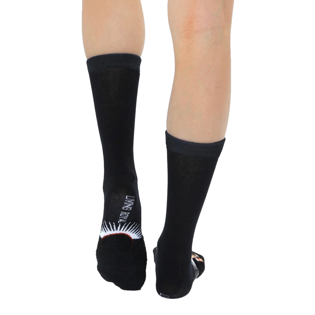 Back view of a pair of Ruth Bader Ginsburg socks worn, displaying the 'Living Royal' logo on the heel. [lf]