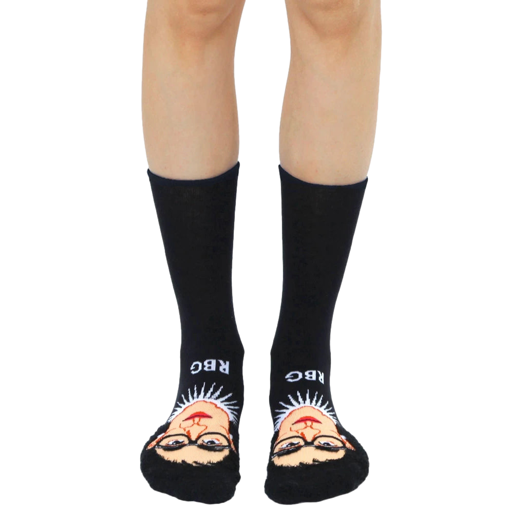 Black crew socks with a colorful 3D portrait of Ruth Bader Ginsburg and 'RBG' text on the cuff. [lf]