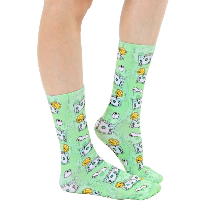 A pair of green socks with a pattern of toilet paper rolls and one hundred dollar bills.