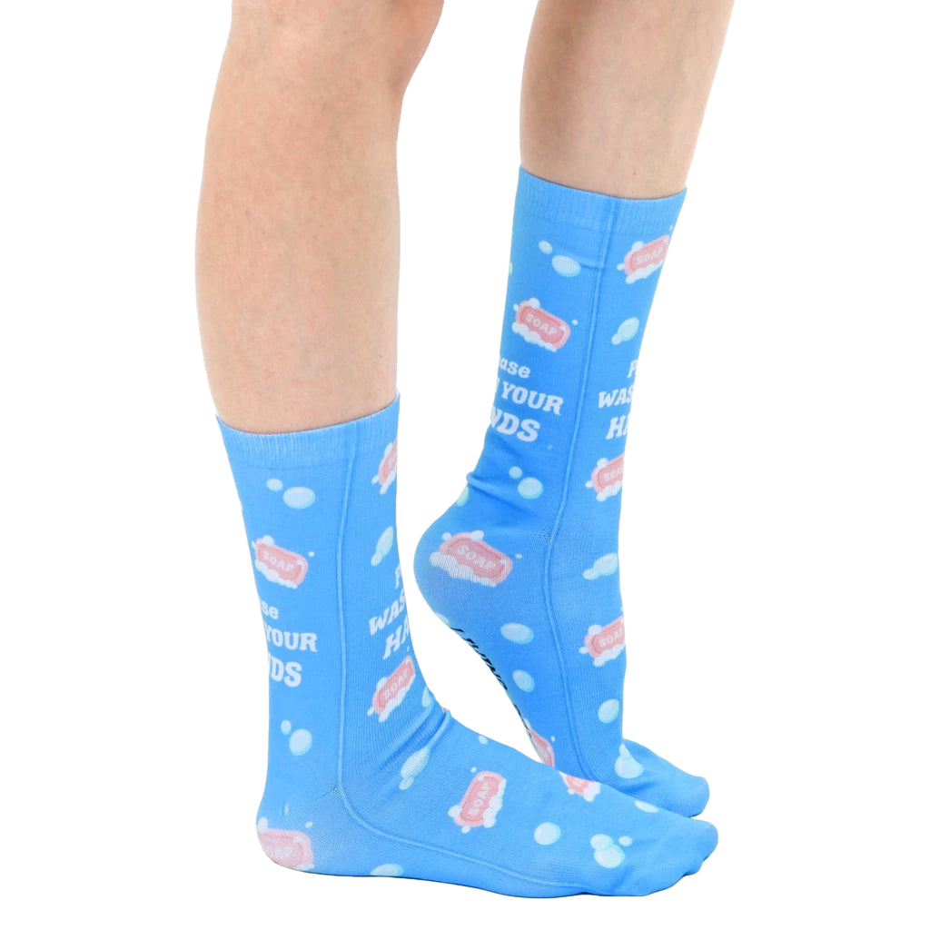Lifestyle shot of model wearing the 'Wash Your Hands' socks, showcasing the fit and design on a person's legs. [lf]