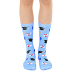 Pair of light blue crew socks with a graduation theme. The design includes black graduation caps, diplomas, and colorful balloons. [lf]