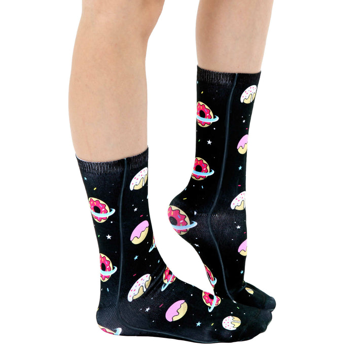 A pair of black socks with a pattern of multicolored donuts and planets.