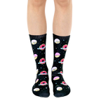 Crew socks in black with pink and white donut designs orbiting like planets against a starry background. [lf]