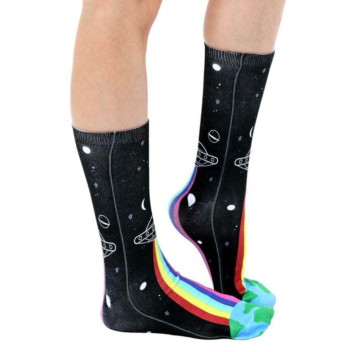 A pair of black socks with a design of white stars, moons, planets, UFOs, and a rainbow on the toes.