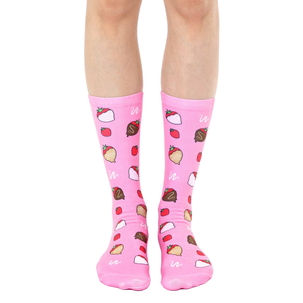 A pair of pink crew socks with a whimsical pattern of chocolate-covered strawberries. [lf]