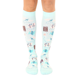 light blue knee-high socks with a colorful travel pattern of suitcases, palm trees, airplanes, and passports.  