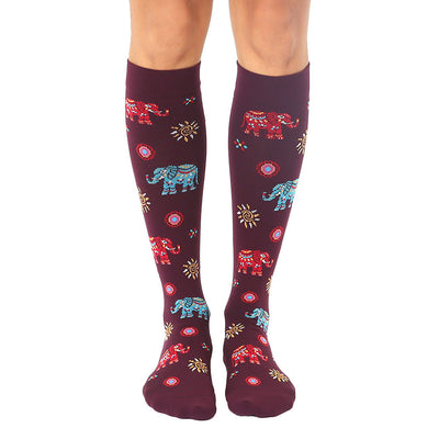 burgundy knee-high socks feature a whimsical pattern of elephants riding elephants.  