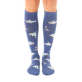 Pair of blue knee-high socks with a repeating pattern of cartoon sharks. Sharks are in teal, white, and orange. [lf]