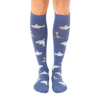 Pair of blue knee-high socks with a repeating pattern of cartoon sharks. Sharks are in teal, white, and orange. [lf]