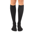 Solid black knee-high socks worn on a person's legs against a dark background, showing a smooth knit texture.
