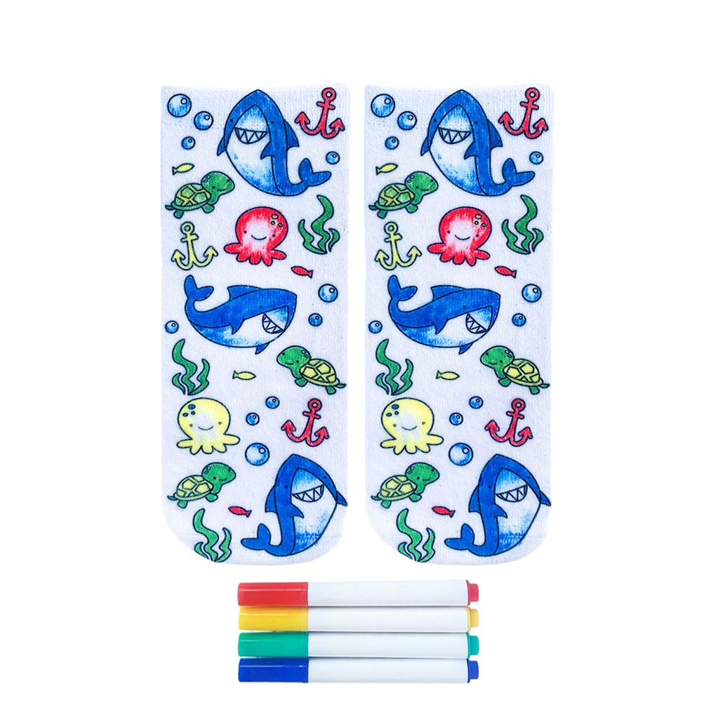 Pair of white ankle socks featuring a colorful ocean design with sharks, turtles, octopuses, and anchors. Includes four fabric markers. [lf]
