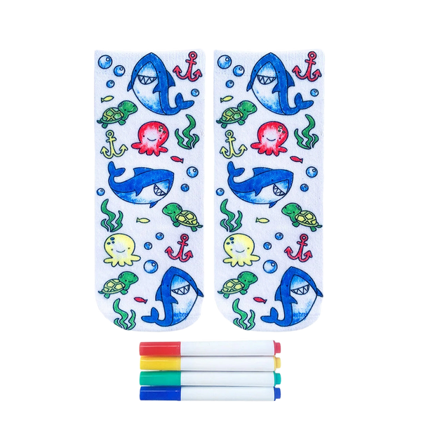 Pair of white ankle socks featuring a colorful ocean design with sharks, turtles, octopuses, and anchors. Includes four fabric markers. [lf]