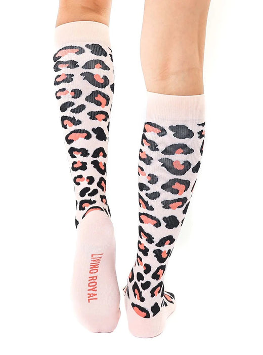 A pair of pink knee-high socks with a black and coral animal print.