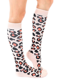 Lifestyle shot showing a woman's legs wearing the coral and black leopard print knee-high socks. [lf]